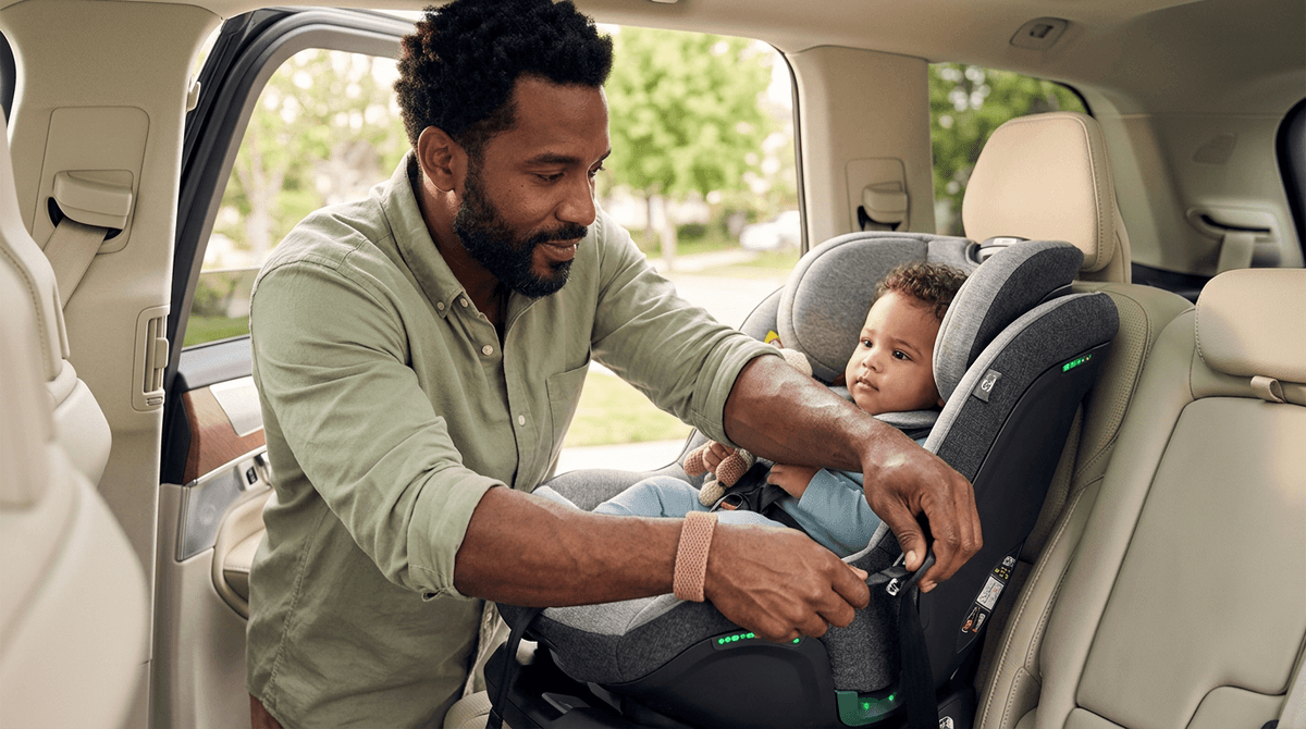 Papa installant un siège auto avec airbag intégré et indicateurs LED dans une voiture moderne