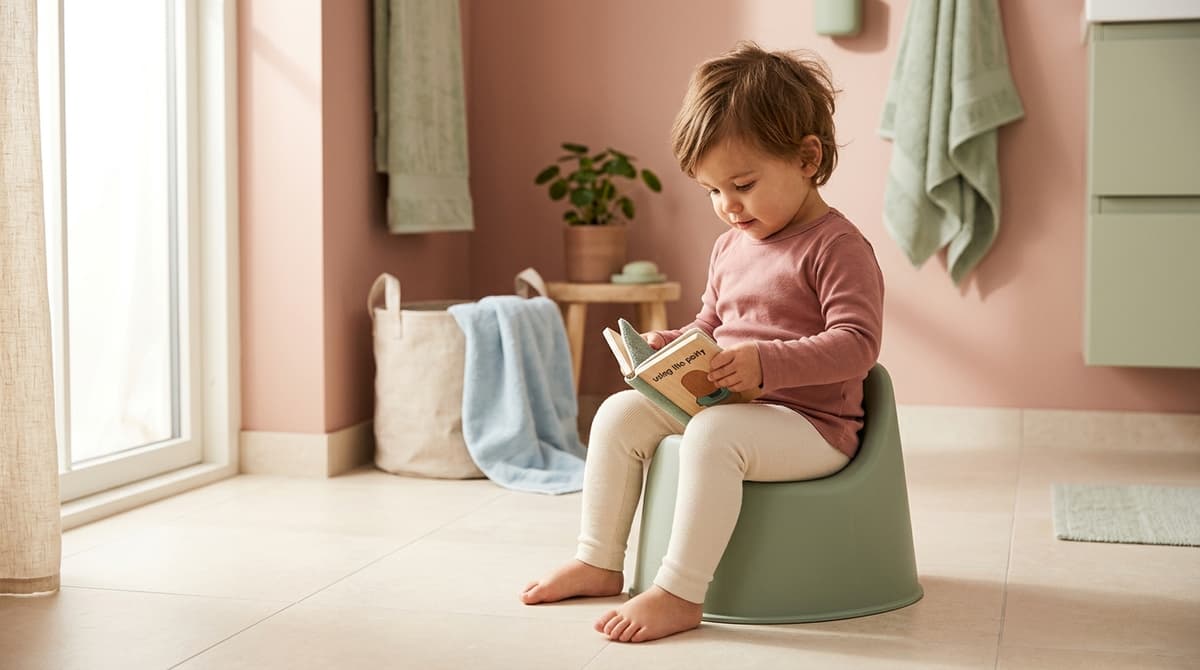 Un jeune enfant assis sur un pot, montrant des signes d'intérêt pour l'apprentissage de la propreté.