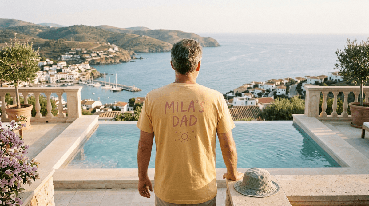 Papa de dos portant un maillot floqué du prénom de son fils au bord d'une piscine face à la mer Méditerranée